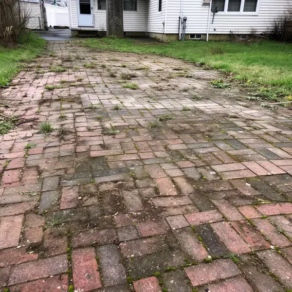 Faded Naples paver driveway with oil stains before sealing